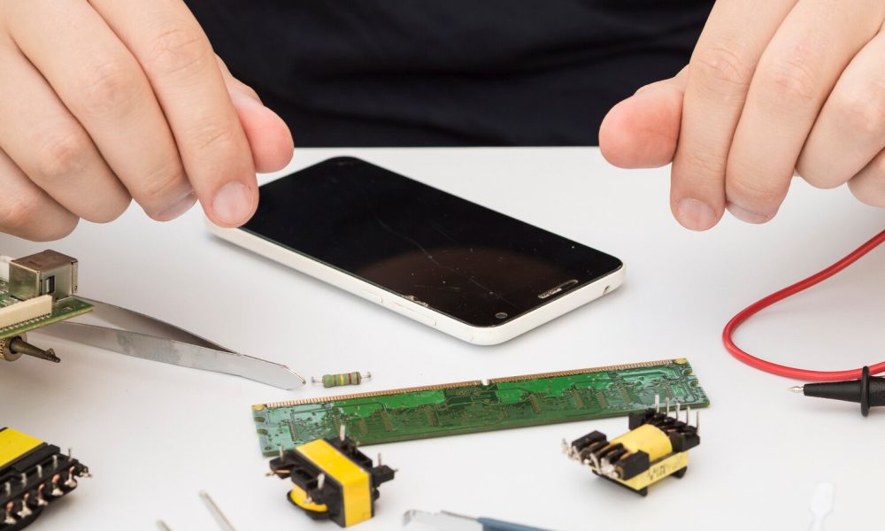 man-sitting-his-work-table-with-electronics_23-2148254089